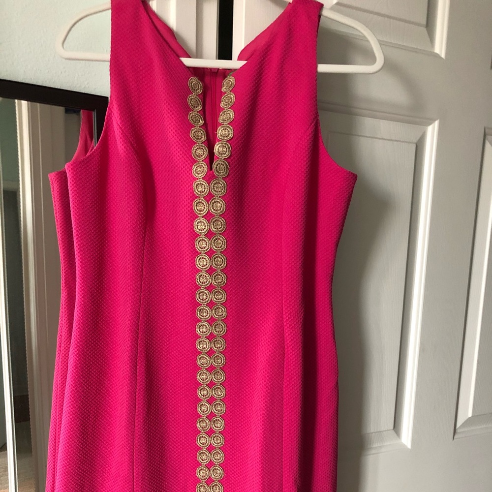 Bright pink dress with gold column detailing.